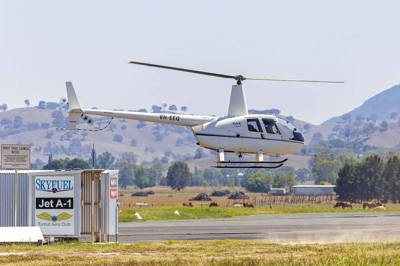 A Robinson R44 helicopter on the ground at a regional airport